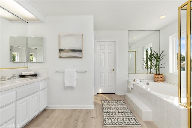 bathroom with vanity, wood-type flooring, and shower with separate bathtub