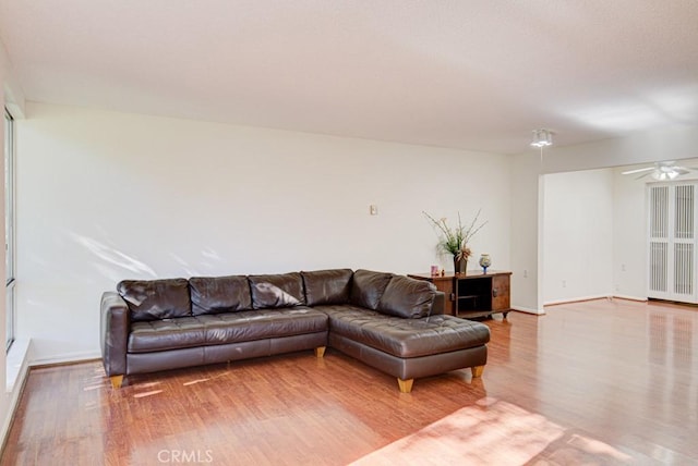 living room with ceiling fan and light hardwood / wood-style flooring