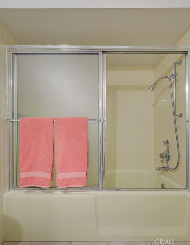 bathroom featuring bath / shower combo with glass door and tile patterned floors