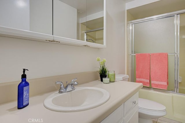 full bathroom with toilet, vanity, and shower / bath combination with glass door