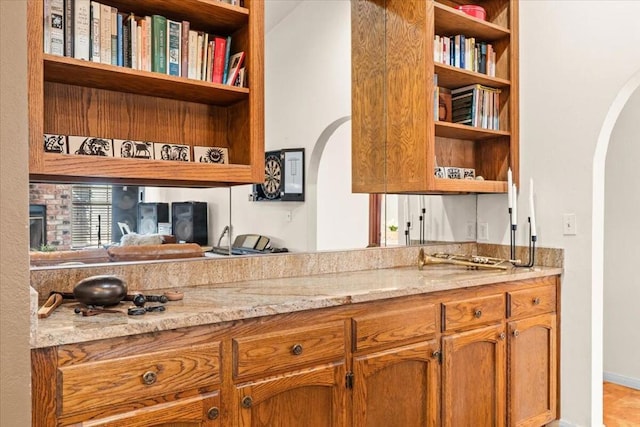 kitchen featuring light stone countertops and built in shelves