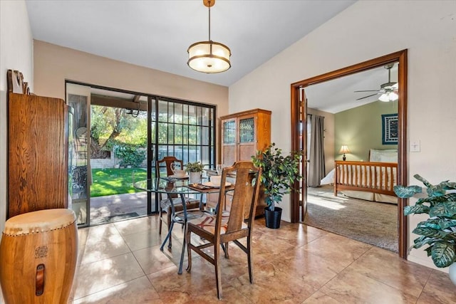 carpeted dining area featuring ceiling fan and vaulted ceiling