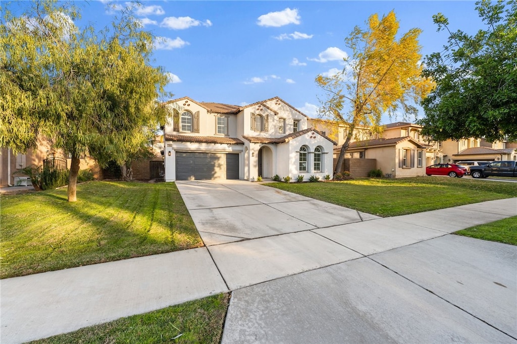 mediterranean / spanish house featuring a front lawn and a garage