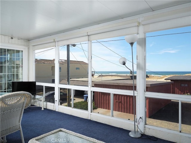 sunroom featuring a water view and plenty of natural light