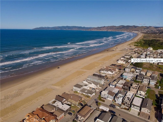 drone / aerial view featuring a view of the beach, a water view, and a residential view