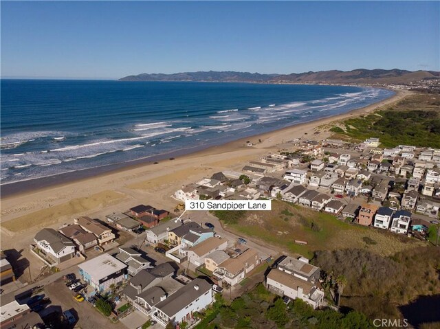 aerial view featuring a view of the beach, a water view, and a residential view