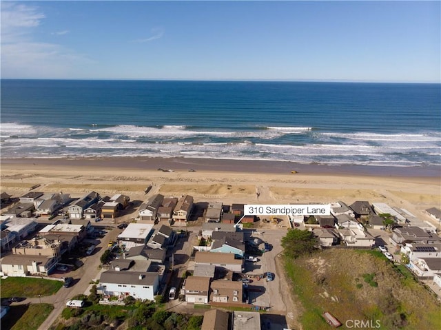 drone / aerial view with a view of the beach, a residential view, and a water view