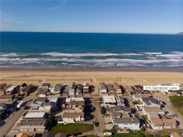 bird's eye view featuring a beach view, a water view, and a residential view