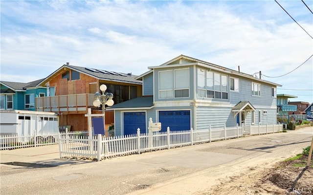 view of front facade with concrete driveway, a fenced front yard, and an attached garage