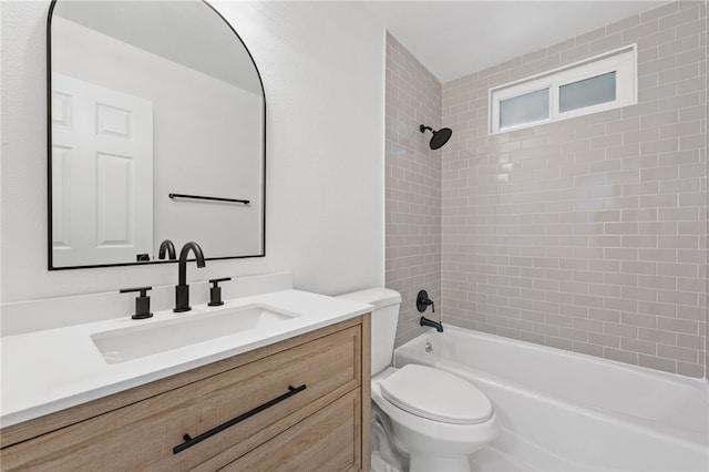 full bathroom with vanity, tiled shower / bath combo, and toilet