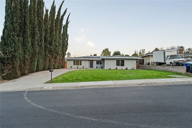 view of front of property featuring a front lawn and solar panels