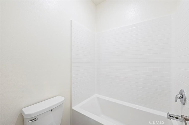 bathroom with washtub / shower combination and toilet