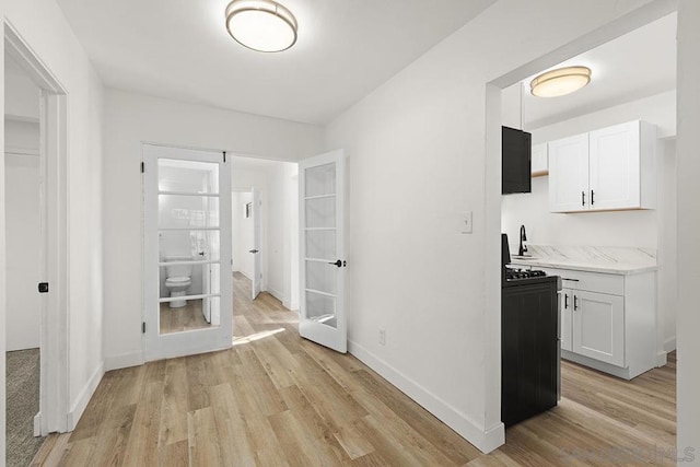 hall with light hardwood / wood-style floors and sink