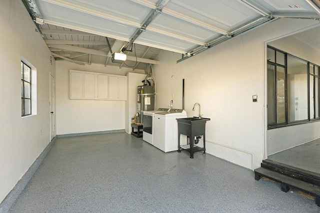 garage with water heater, sink, independent washer and dryer, and a garage door opener