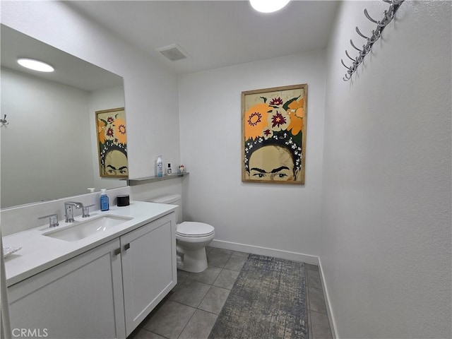 bathroom featuring toilet, vanity, and tile patterned flooring