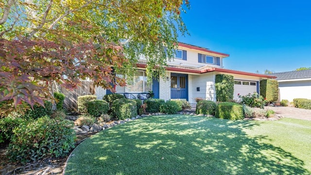 view of front of home with a garage and a front lawn