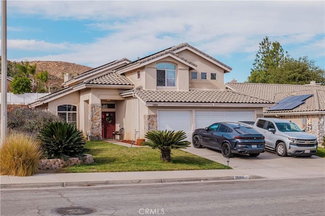 mediterranean / spanish house with a garage and a front yard