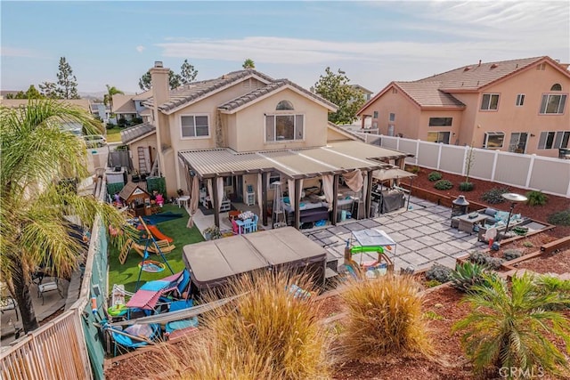 back of house featuring a playground and a patio area