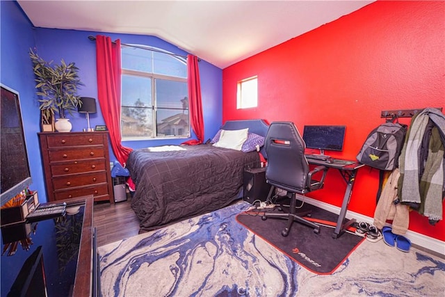 bedroom with lofted ceiling and wood-type flooring