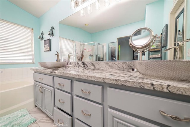 bathroom featuring independent shower and bath, vanity, and plenty of natural light