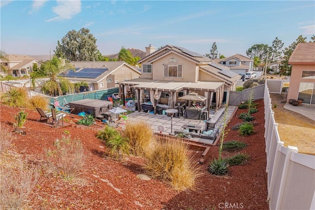 rear view of house with a patio and solar panels