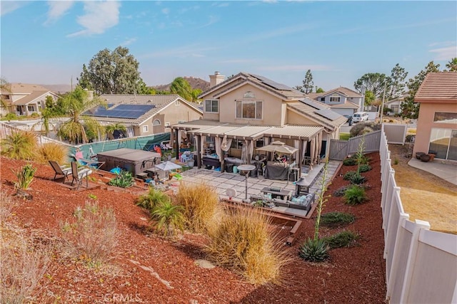 rear view of house featuring a patio area and solar panels