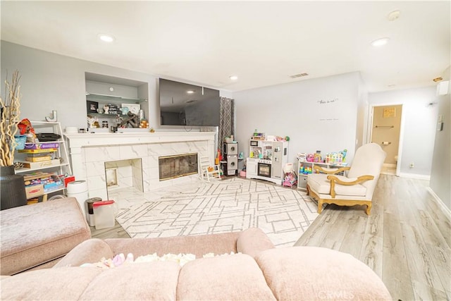 living room with a premium fireplace and light wood-type flooring