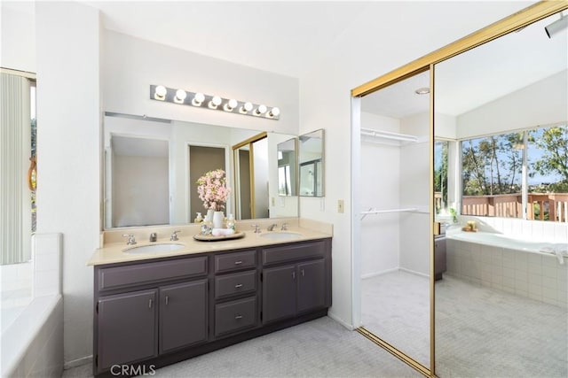 bathroom with vanity and tiled tub