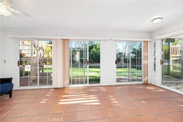 doorway to outside featuring ceiling fan, tile patterned flooring, and a wealth of natural light