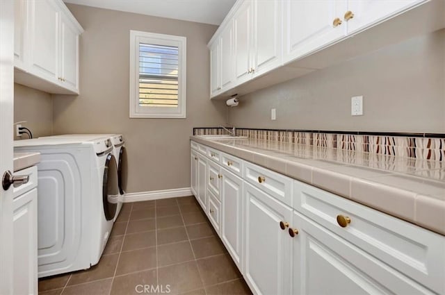 laundry area featuring cabinets, sink, dark tile patterned flooring, and independent washer and dryer