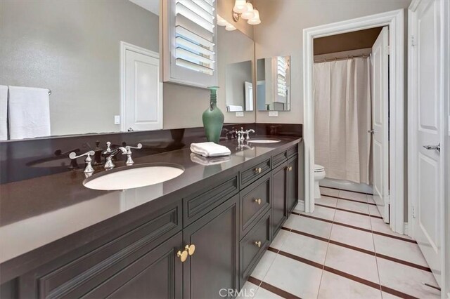 bathroom with vanity, tile patterned floors, toilet, and walk in shower