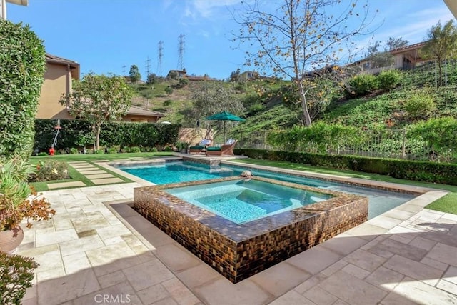 view of swimming pool featuring a patio area and an in ground hot tub