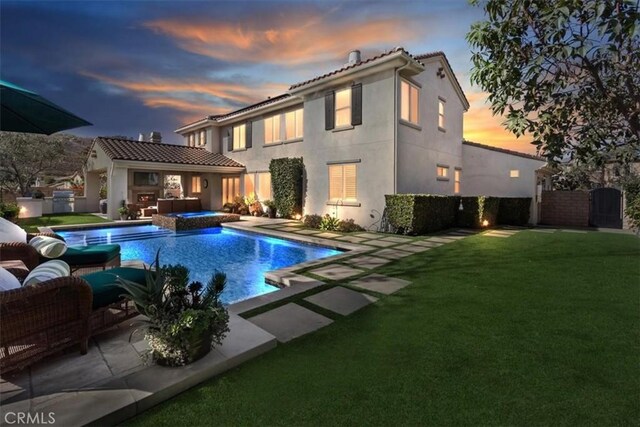 pool at dusk with an outdoor living space, a patio, an in ground hot tub, and a lawn