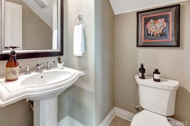 bathroom with lofted ceiling, baseboards, a sink, and toilet