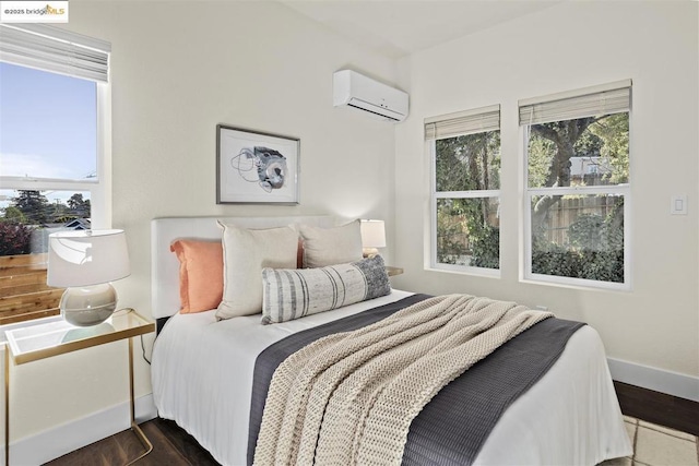 bedroom featuring multiple windows, dark hardwood / wood-style floors, and a wall unit AC