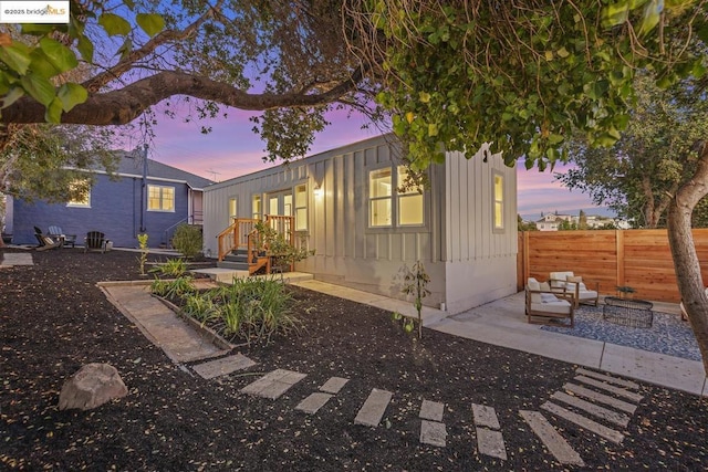 back house at dusk with an outdoor hangout area and a patio