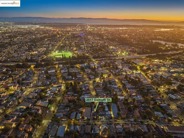 aerial view at dusk featuring a mountain view