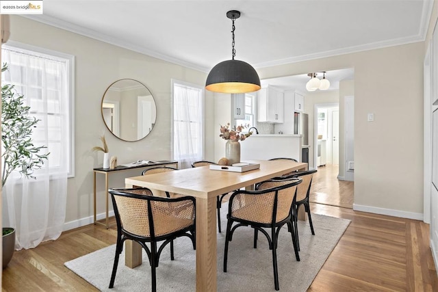 dining space featuring light hardwood / wood-style flooring and ornamental molding