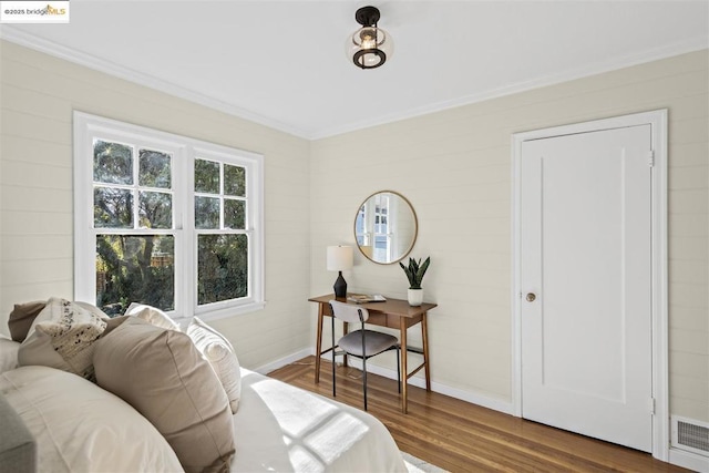 bedroom featuring wood-type flooring and crown molding