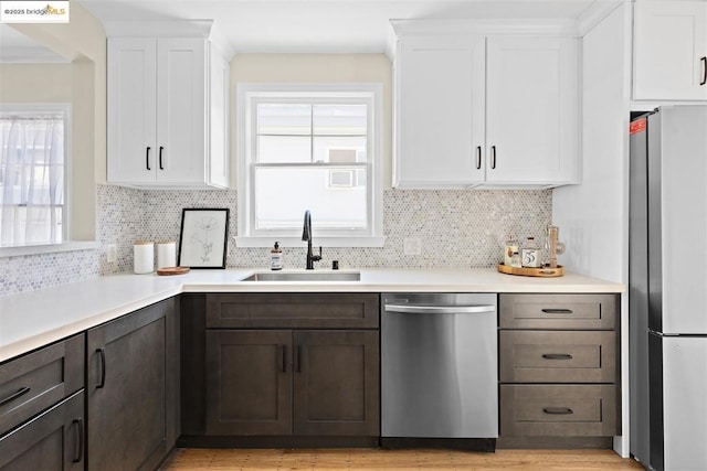 kitchen featuring white cabinets, sink, stainless steel appliances, and dark brown cabinetry