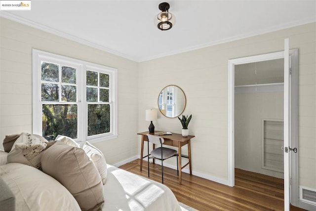 bedroom with wood-type flooring, a closet, and crown molding