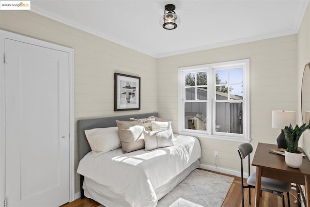 bedroom with light wood-type flooring and crown molding