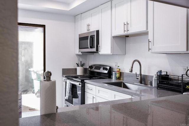 kitchen with sink, light stone countertops, white cabinets, and stainless steel appliances