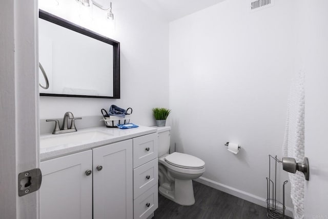 bathroom featuring toilet, vanity, and hardwood / wood-style flooring