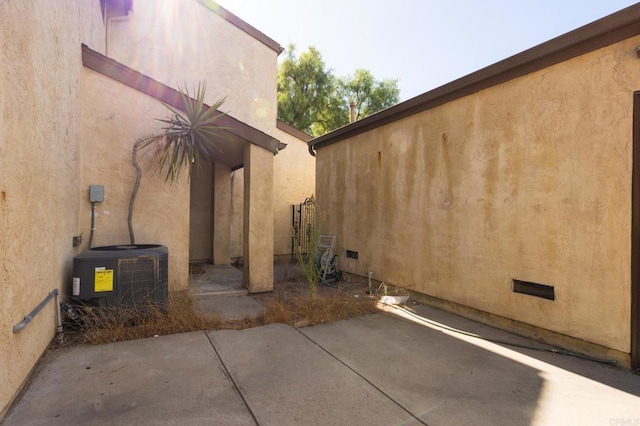 view of property exterior with central air condition unit and a patio