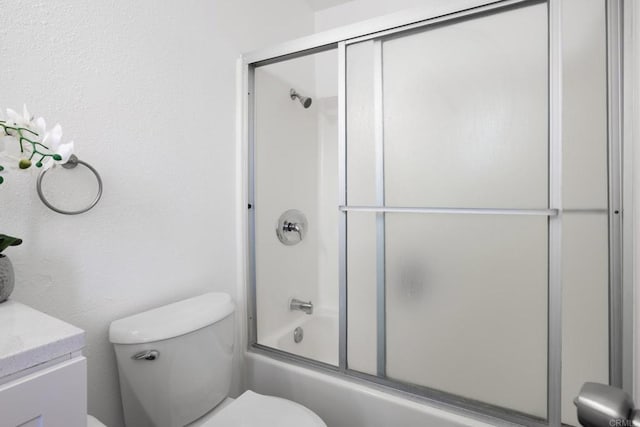 full bathroom featuring toilet, combined bath / shower with glass door, and vanity