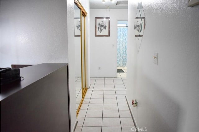 corridor with light tile patterned flooring