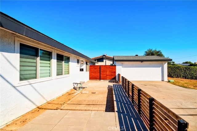 view of patio with an outbuilding and a garage