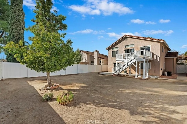 rear view of property with central AC unit and a deck