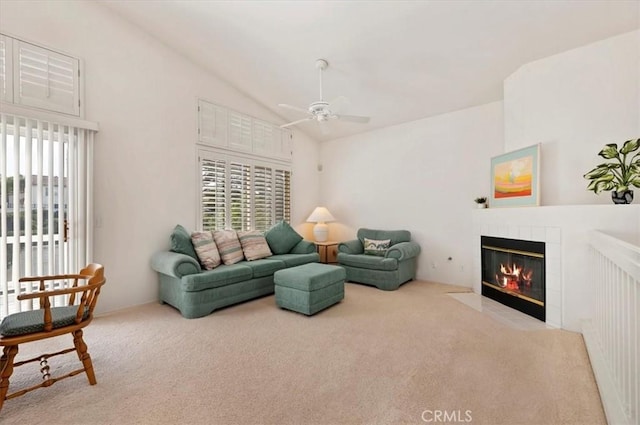 carpeted living room featuring ceiling fan, vaulted ceiling, and a fireplace